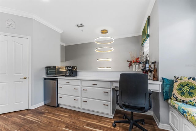 home office featuring crown molding, dark hardwood / wood-style floors, and built in desk