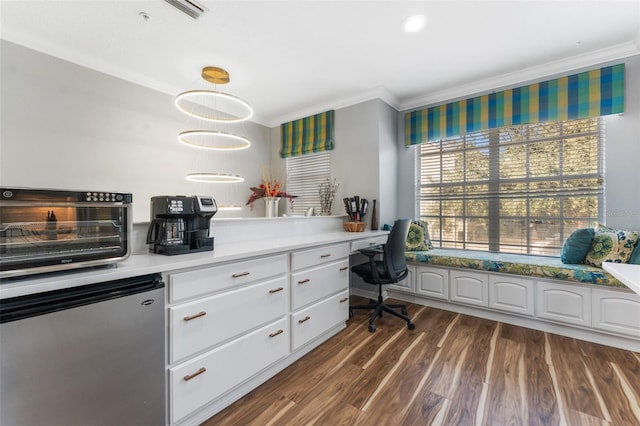 home office with ornamental molding, dark wood-type flooring, and built in desk