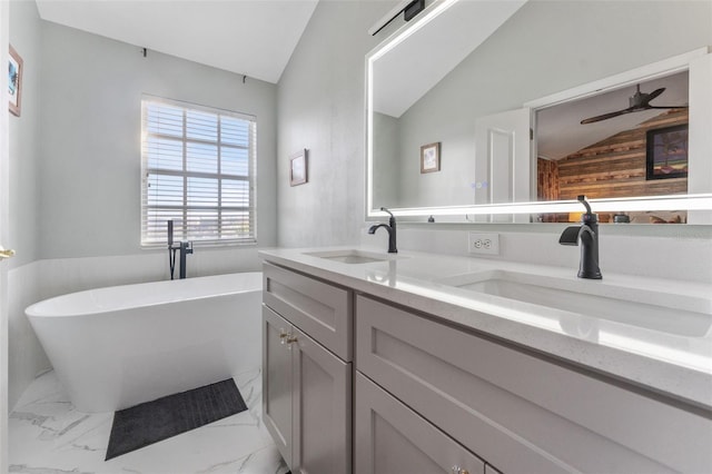 bathroom featuring vanity, lofted ceiling, ceiling fan, and a tub to relax in