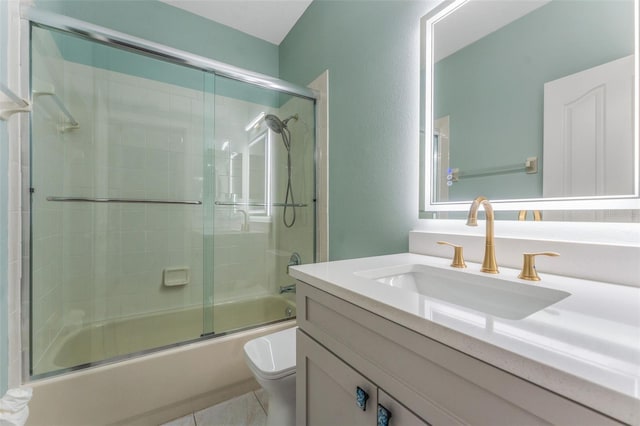 full bathroom with vanity, combined bath / shower with glass door, tile patterned floors, and toilet