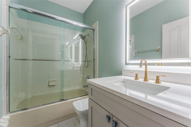 full bathroom with vanity, combined bath / shower with glass door, tile patterned floors, and toilet