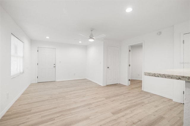 unfurnished living room featuring ceiling fan and light hardwood / wood-style floors