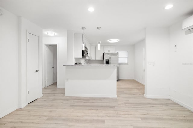 kitchen with decorative light fixtures, light hardwood / wood-style flooring, kitchen peninsula, stainless steel appliances, and white cabinets