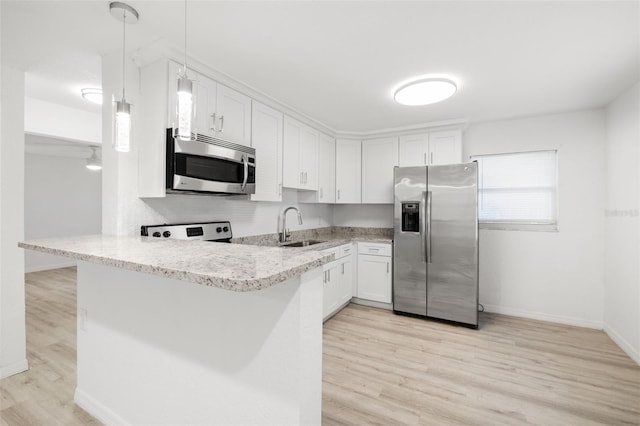 kitchen with white cabinetry, stainless steel appliances, decorative light fixtures, and kitchen peninsula