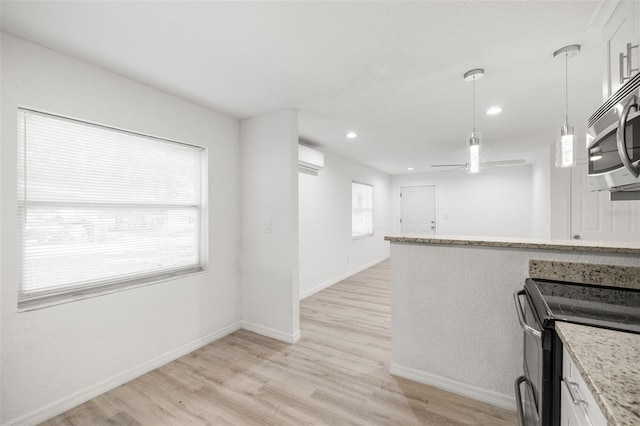 kitchen with white cabinetry, appliances with stainless steel finishes, decorative light fixtures, and light hardwood / wood-style flooring