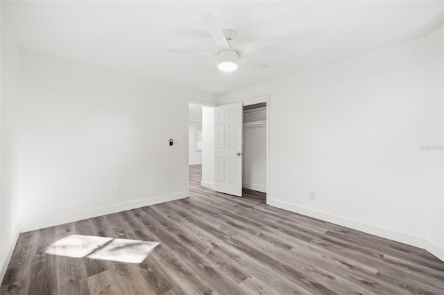 unfurnished bedroom with hardwood / wood-style floors, ceiling fan, and a closet