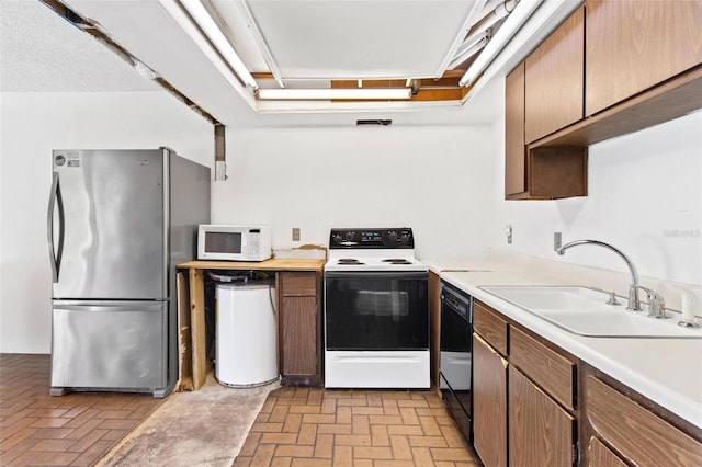 kitchen featuring electric stove, stainless steel fridge, black dishwasher, and sink