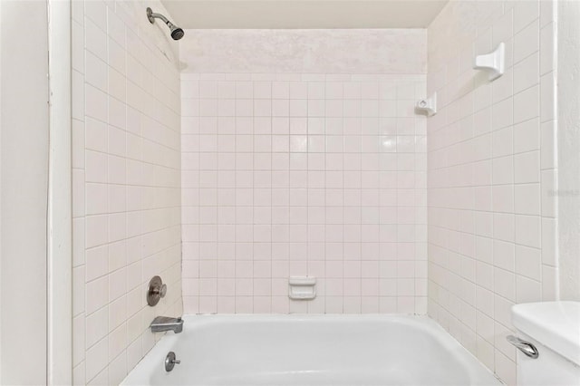 bathroom with tiled shower / bath and toilet