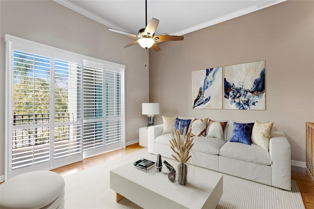 living room featuring crown molding, wood-type flooring, and ceiling fan