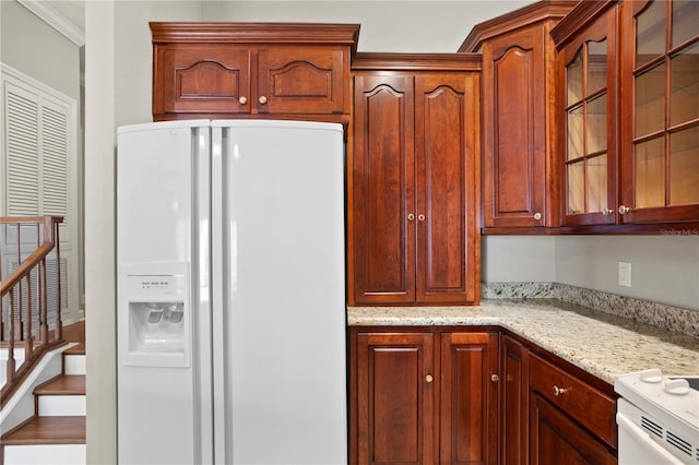 kitchen featuring light stone countertops and white fridge with ice dispenser