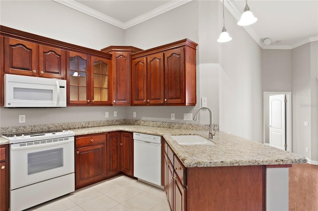 kitchen featuring sink, white appliances, decorative light fixtures, and kitchen peninsula