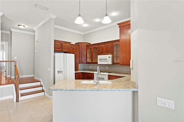 kitchen with pendant lighting, ornamental molding, kitchen peninsula, light stone countertops, and white appliances