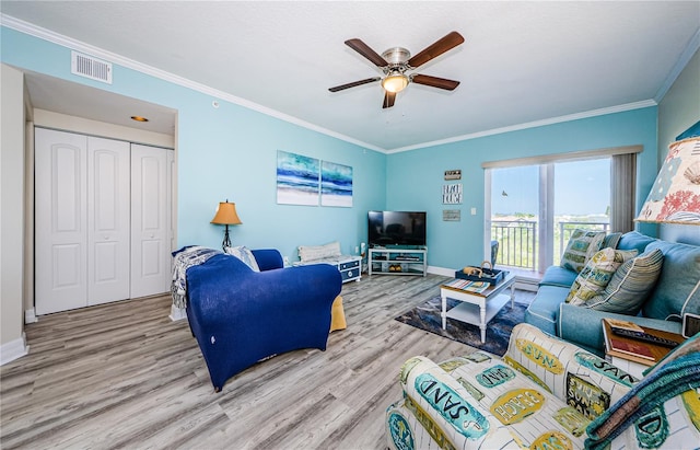 living room with crown molding, light hardwood / wood-style floors, and ceiling fan