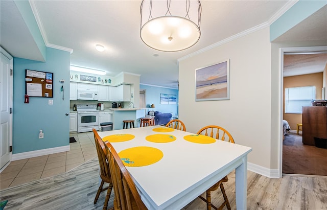 dining space featuring crown molding and light wood-type flooring