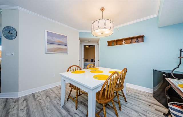 dining area with light hardwood / wood-style flooring and ornamental molding