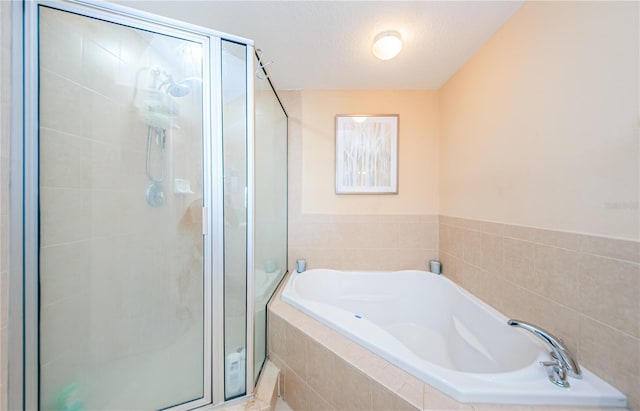 bathroom featuring shower with separate bathtub and a textured ceiling