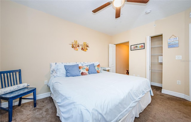 carpeted bedroom with a spacious closet, a closet, and ceiling fan