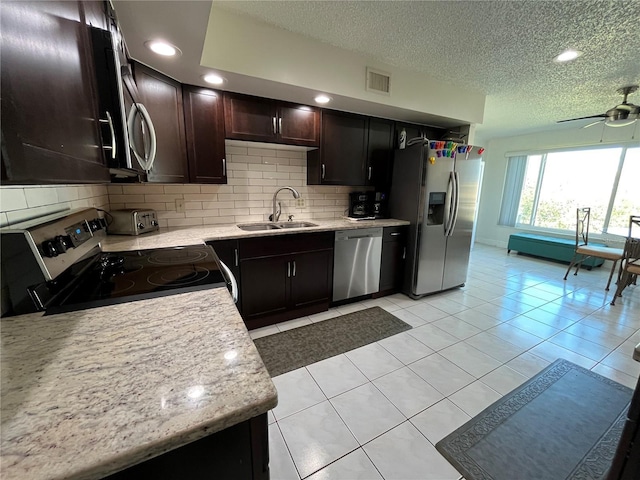 kitchen with sink, light tile patterned floors, ceiling fan, stainless steel appliances, and tasteful backsplash