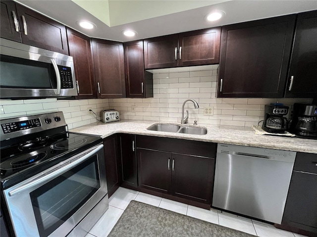 kitchen featuring tasteful backsplash, dark brown cabinetry, appliances with stainless steel finishes, and sink