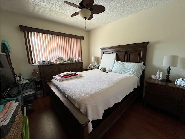 bedroom with ceiling fan, dark hardwood / wood-style flooring, and a textured ceiling