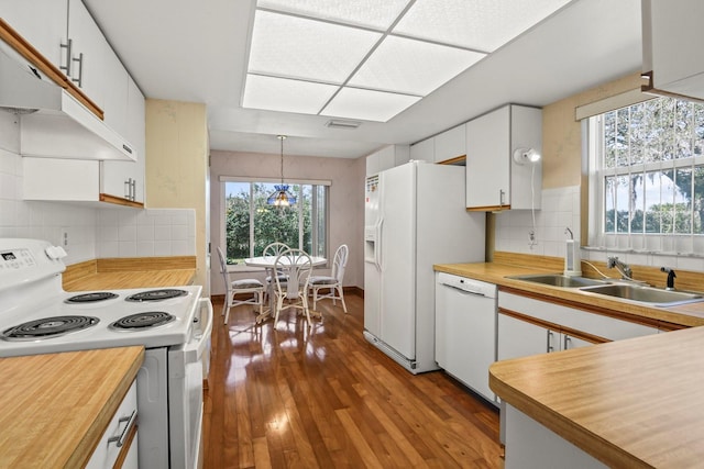 kitchen featuring sink, white cabinetry, hanging light fixtures, light wood-type flooring, and white appliances