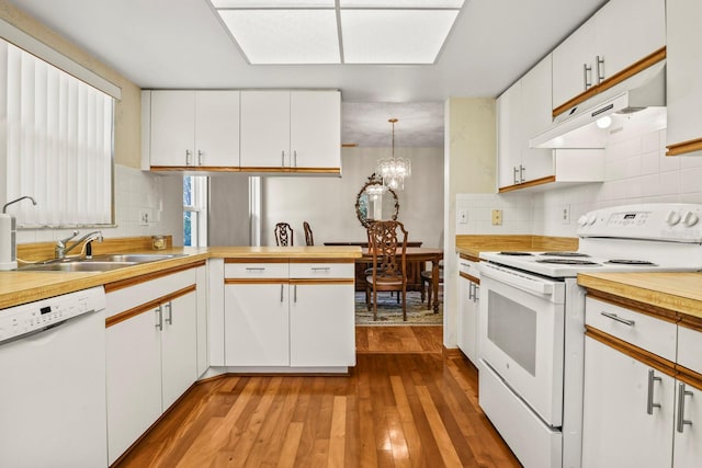 kitchen featuring pendant lighting, white appliances, sink, and white cabinets