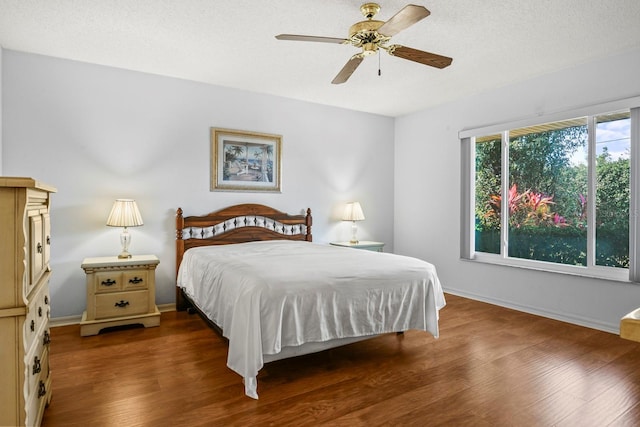 bedroom featuring ceiling fan, wood-type flooring, and a textured ceiling