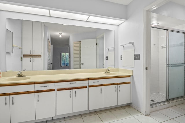 bathroom featuring tile patterned flooring, vanity, and walk in shower