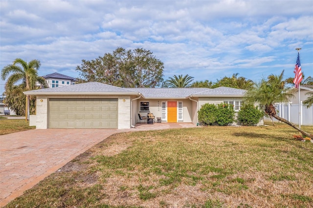 single story home with a garage and a front lawn