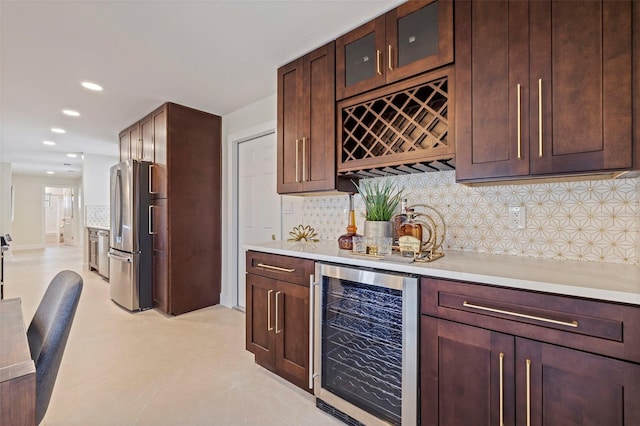 bar featuring stainless steel fridge, beverage cooler, and backsplash