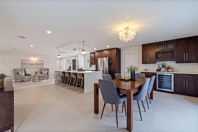 dining room with wine cooler, light tile patterned floors, and indoor wet bar