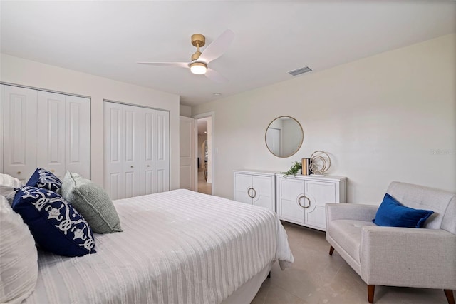 bedroom featuring ceiling fan and two closets