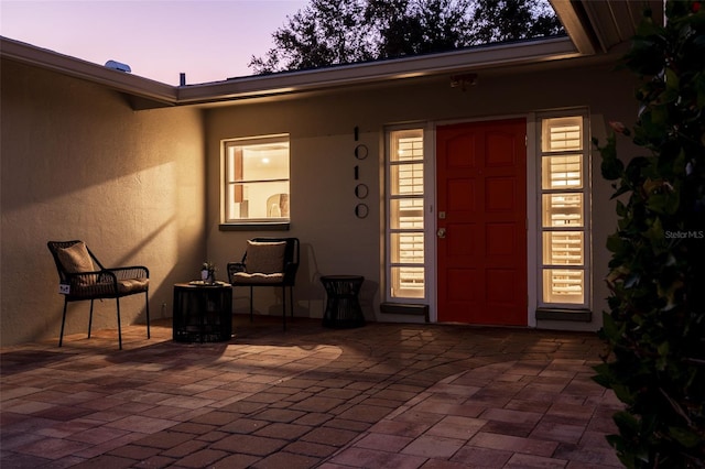 exterior entry at dusk with a patio