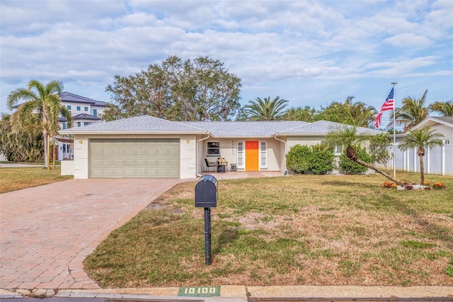 ranch-style house with a garage and a front lawn