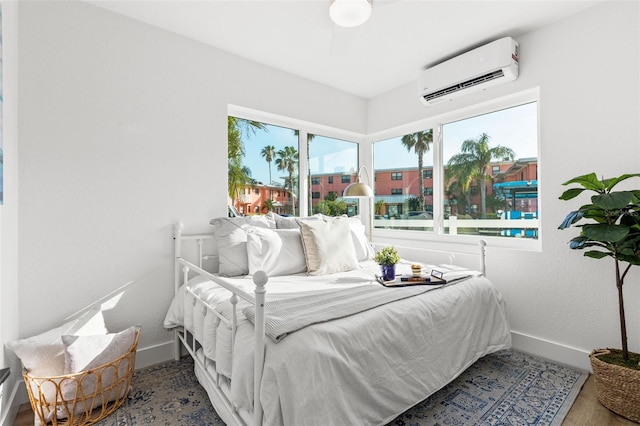 bedroom with hardwood / wood-style flooring and an AC wall unit