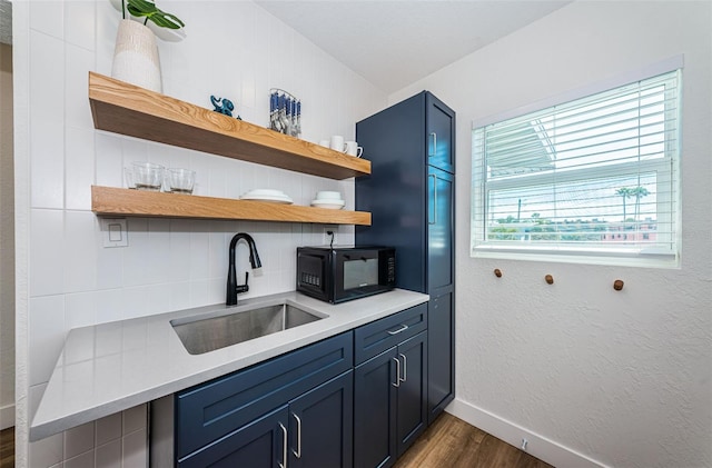 kitchen featuring tasteful backsplash, sink, dark hardwood / wood-style floors, and blue cabinets