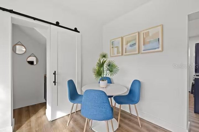 dining room featuring wood-type flooring and a barn door