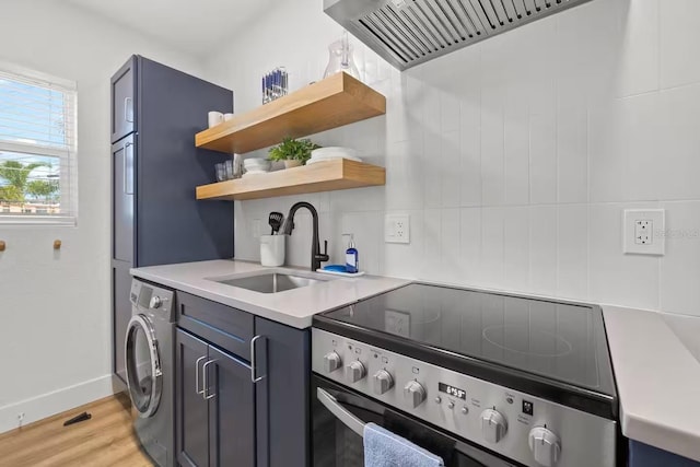 kitchen featuring sink, light hardwood / wood-style flooring, stainless steel electric range, washer / clothes dryer, and wall chimney range hood