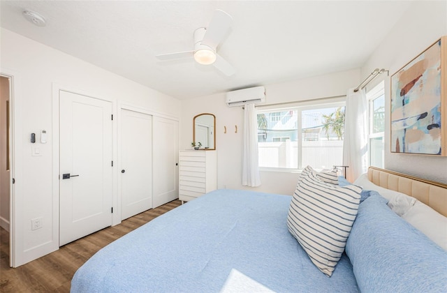 bedroom with hardwood / wood-style floors, a wall mounted AC, and ceiling fan