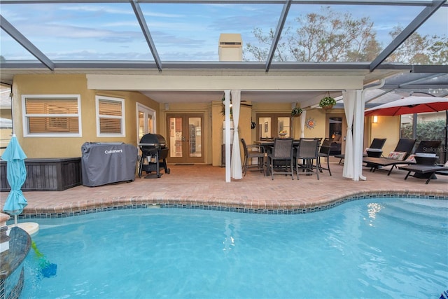 view of pool with french doors, area for grilling, and a patio