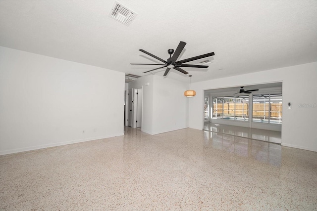 unfurnished living room featuring ceiling fan and a textured ceiling