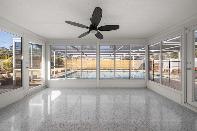 unfurnished sunroom with ceiling fan