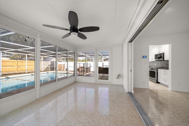 unfurnished sunroom with ceiling fan