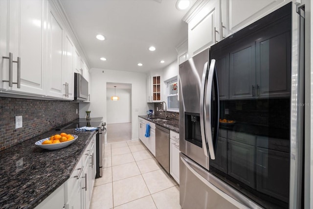 kitchen with sink, stainless steel appliances, dark stone counters, and white cabinets