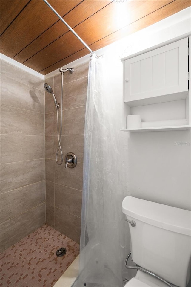 bathroom featuring wooden ceiling, toilet, and a stall shower