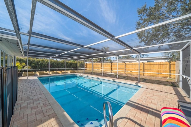 view of pool with a patio and glass enclosure