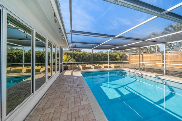 view of swimming pool featuring a fenced in pool, a patio, a fenced backyard, and glass enclosure