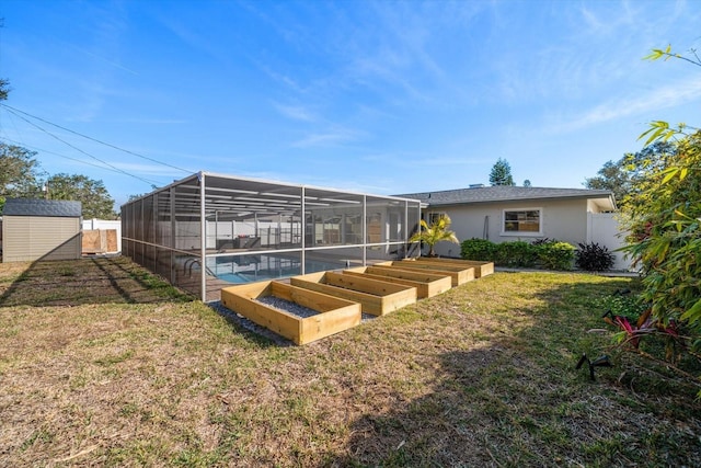 rear view of house featuring fence, a storage shed, an outdoor structure, and a garden