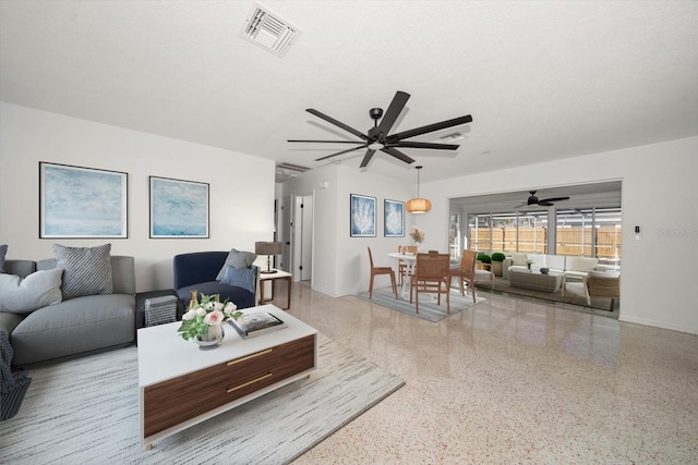 living room with visible vents, baseboards, a textured ceiling, speckled floor, and a ceiling fan