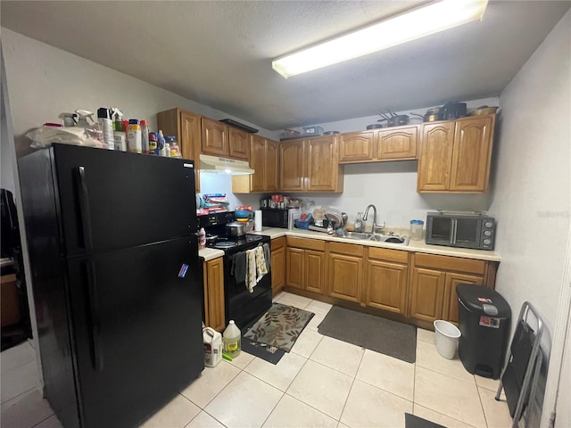 kitchen featuring sink, light tile patterned floors, and black appliances